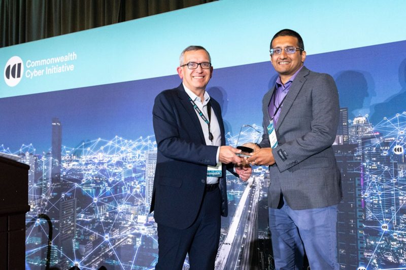 CCI Executive Director Luiz DaSilva presents the 2024 Impact Award to Sachin Shetty.