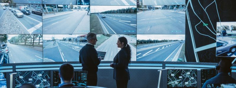 people in front of screens showing roads and highways