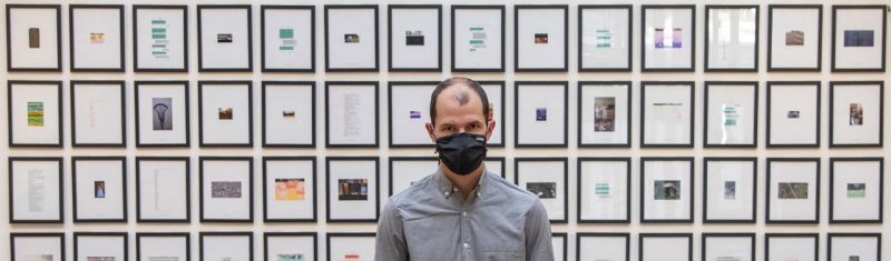 Curator Michael McDermott stands in front of Undeleted Exhibit on George Mason Campus