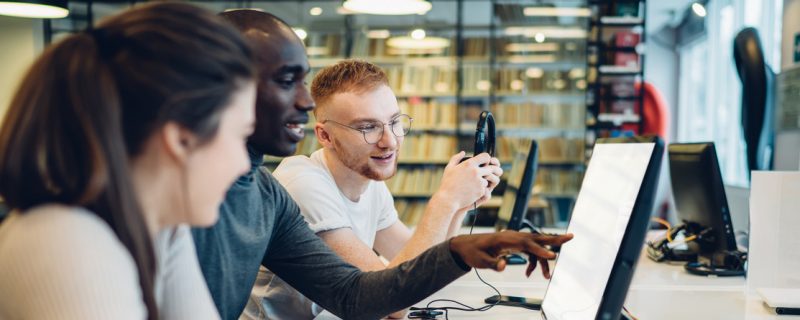 Software engineers collaborating on a project, analyzing code on computer monitors