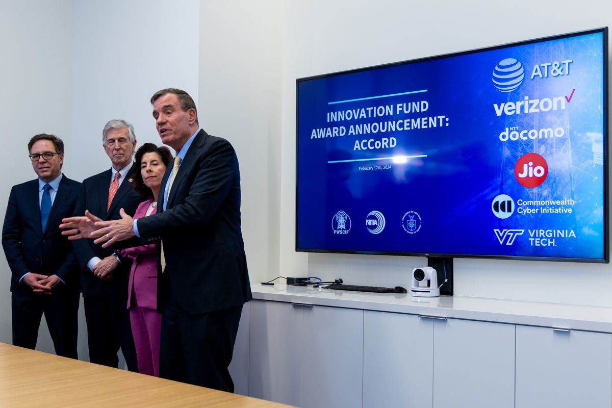 Group stands beside screen on innovation fund announcement