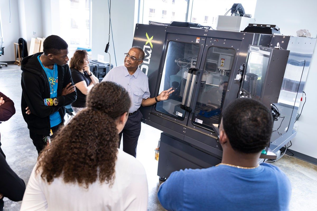 Teacher explains equipment to students in lab