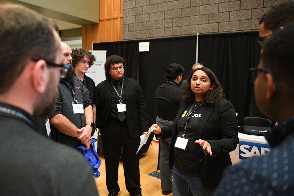 Students speak with a representative from Microsoft at Cyber Fusion 2024