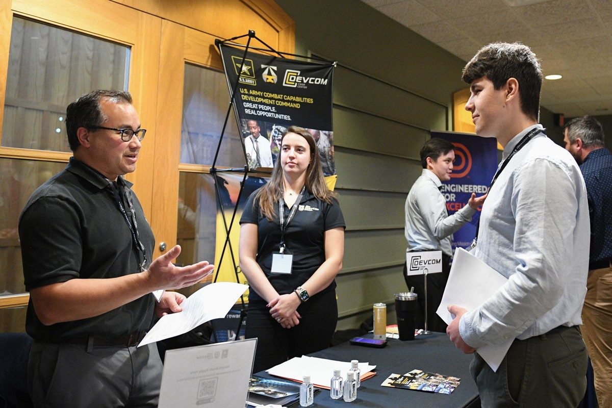 Students speak with representatives from DevCom at Cyber Fusion 2024