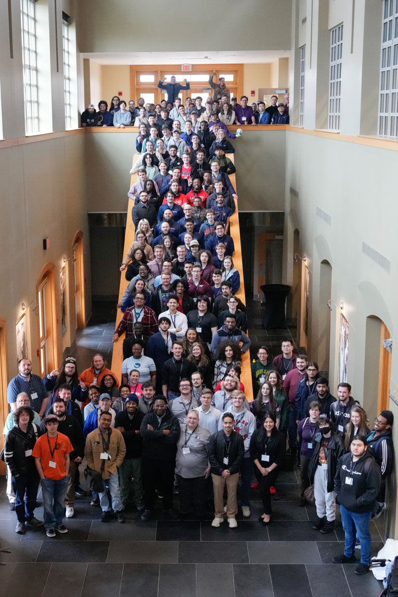 150 people pose on balcony, on stairs, and on floor