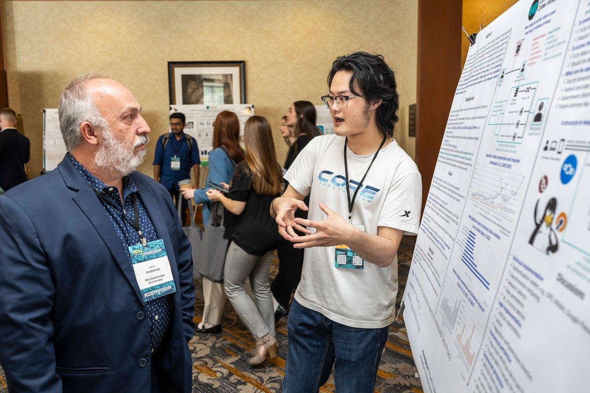 William & Mary’s Shaun Liu, right, discusses his poster, “Private System as Digital Real Property for Individuals’ Data Privacy” with John Costanzo, Chief Administrative Officer of Old Dominion University’s  Coastal Virginia Center for Cyber Innovation. 