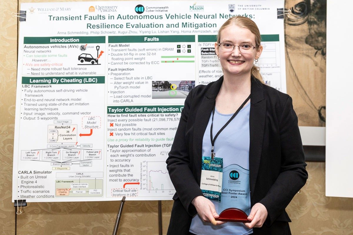 Student holds award in front of poster