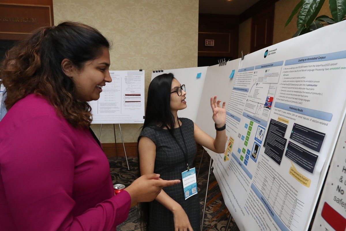 Two women in front of posters at 2023 CCI Symposium 