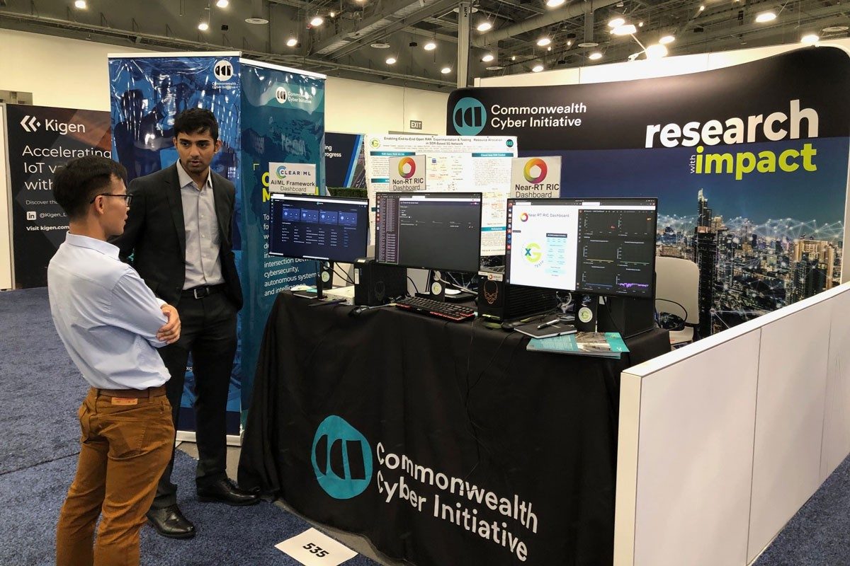 Aditya Sathish, right, talks about O-RAN (Open Radio Access Network) research with a Mobile World Congress delegate. The O-RAN) Alliance has designated the Commonwealth Cyber Initiative as North American Open Testing and Integration Center (OTIC) in Washington D.C./Arlington Va.