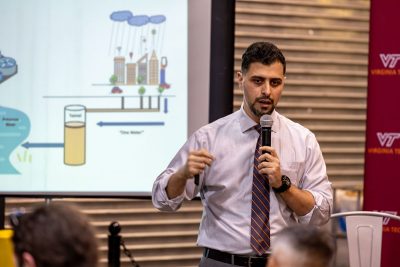 CCI researcher Feras Batarseh in front of screen with water illustrations