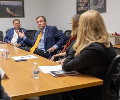 Mark Warner at table with Virginia Tech officials