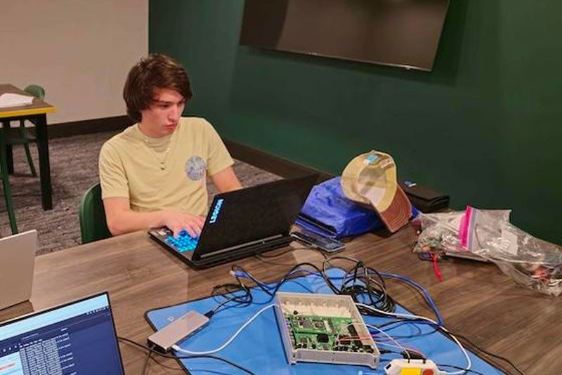 mason student works on laptop and router