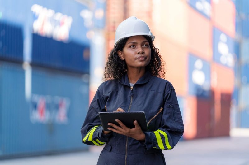 Woman in hard hat checks inventory for shipping