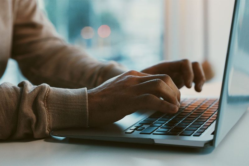 hands typing on laptop keyboard