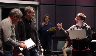Actors perform a scene with laptop and scripts