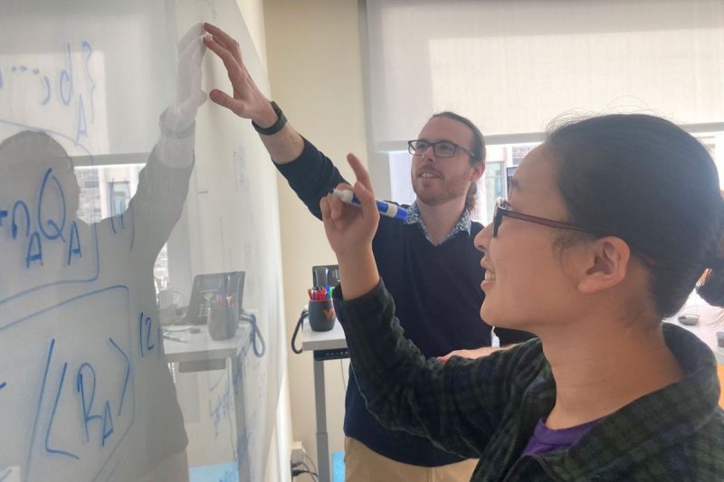 Teacher and student discuss quantum equations on white board at Virginia Tech