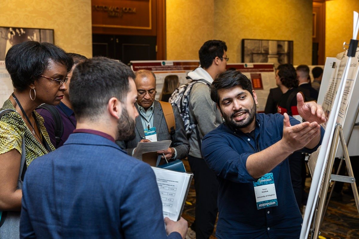Members of the judging panel talk with Tahsin Mullick, right, a Ph.D. student at the University of Virginia. Students from across Virginia presented their research in poster form at the CCI Symposium. Photo by Ron Aira for CCI