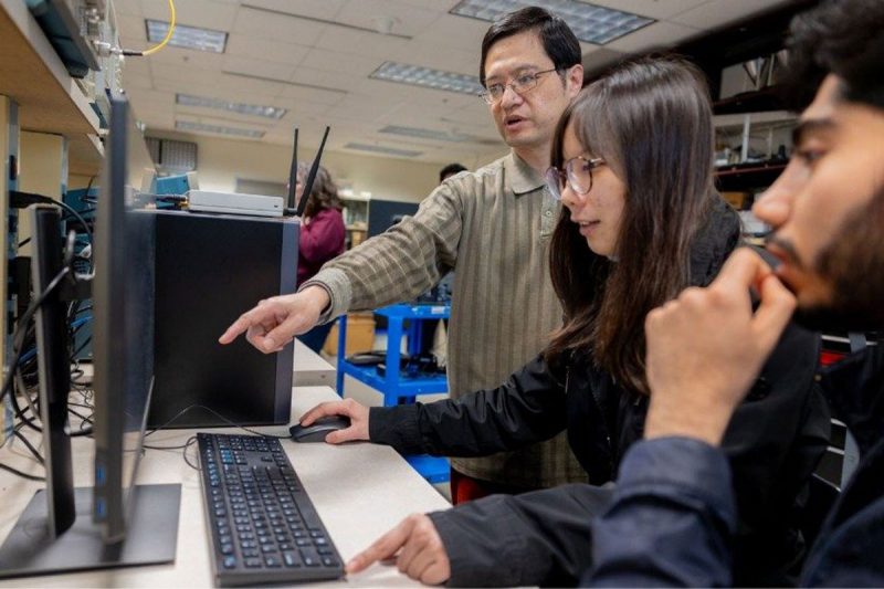 Instructor works with students looking at computer screens