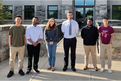Six people standing outside Virginia Tech campus building