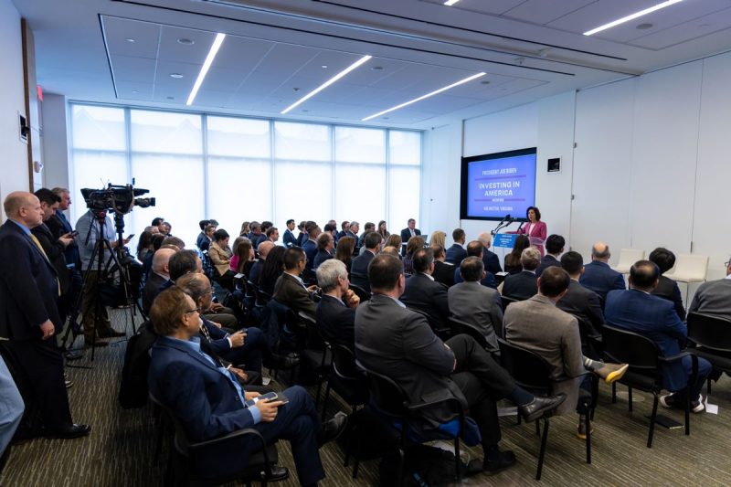 Seated crowd sits and listens to woman speak