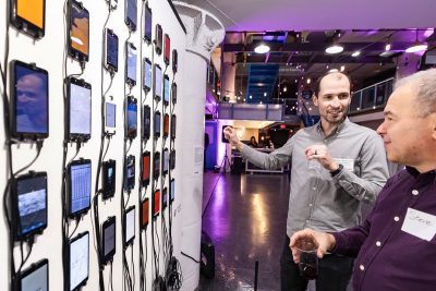 Men discuss mobile phone exhibit at Torpedo Factory