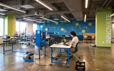 Researcher works on laptop surrounded by equipment to conduct research