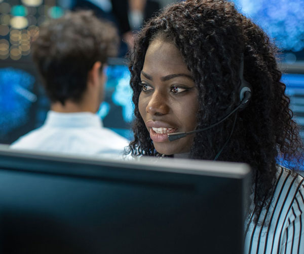 Woman wears headphones in computer room 