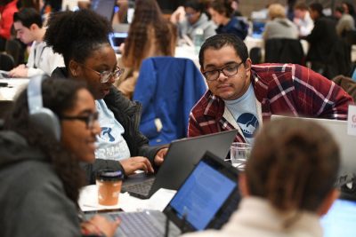 Crowd of students work on laptops in CTF competition