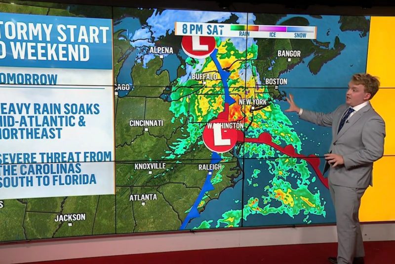 A person stands in front of a weather map that shows temperatures and weather conditions in various locations. 