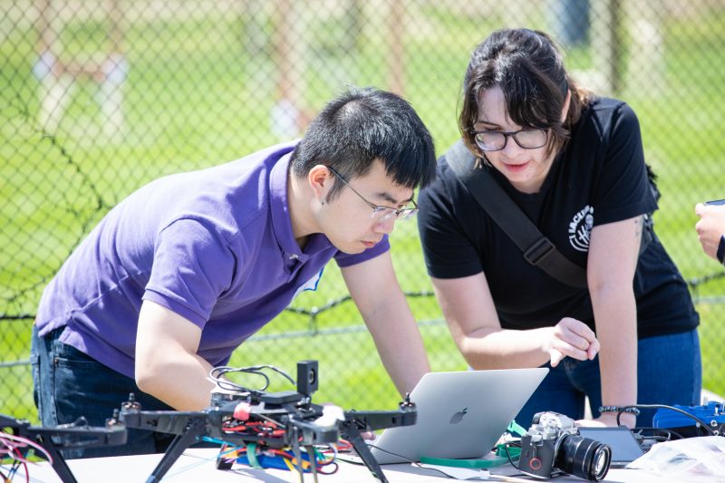 Two students work on a drone in Virginia Tech's Drone Cage as part of an experiential learning project funded by the Commonwealth Cyber Initiative. 